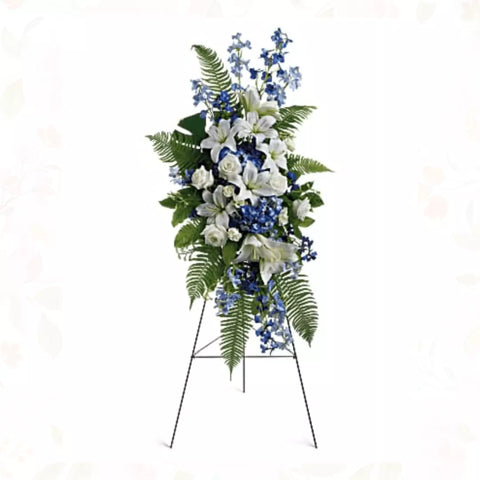 Pedestal y Arreglo Fúnebre, Corona y Pedestal "Brisa Del Océano". contiene: un caballete hortensias azules y delfinios, rosas blancas y lirios asiáticos, además de helechos y hojas tropicales. Flores 24 Horas, Bogotá, Colombia