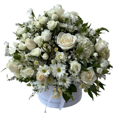 Caja blanca con rosas blancas y crema, margaritas y flores complementarias en una composición abundante y equilibrada.