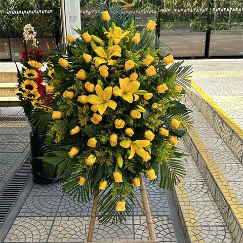 Corona Fúnebre Serenidad, Flores de Condolencias, 24 Horas, Celebre la vida de su ser querido con la Corona Fúnebre Serenidad, adornada con lirios y rosas amarillas, simbolizando la paz y la serenidad que su ser querido merecía, entregamos su corona fúnebre en funerarias en Bogotá