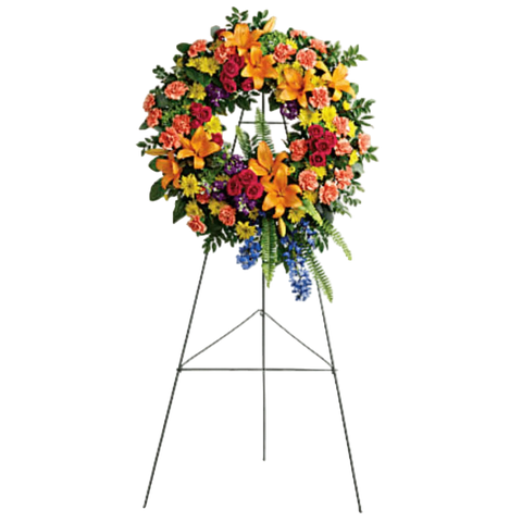Pedestal y Arreglo Fúnebre, Corona y Pedestal "Guirnalda Serenidad". contiene: hortensias verdes, rosas en aerosol rosa intenso, lirios asiáticos naranjas, claveles naranjas, delfinio azul, púrpura, crisantemos en aerosol amarillo, arándano, pittosporum abigarrado, helecho espada, eucalipto y hoja de limón. Flores 24 Horas, Bogotá, Colombia