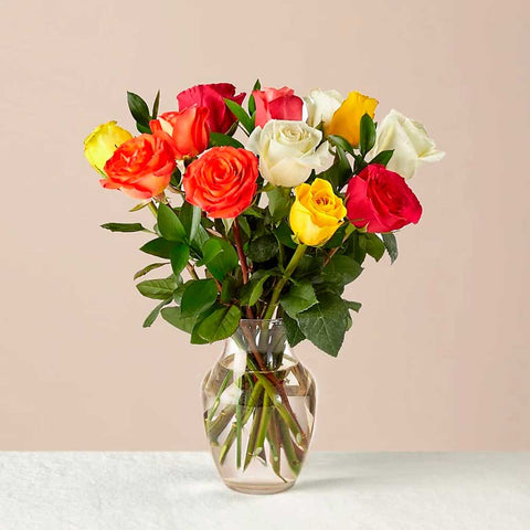 12 Rosas Mixtas En Florero: Colorido y floreciente, este vibrante ramo de una docena de rosas es un estimulante instantáneo del estado de ánimo. Floristería Flores 24 Horas