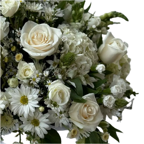 Acercamiento a las rosas blancas y crema, margaritas y agrupaciones de pequeñas flores blancas del arreglo.