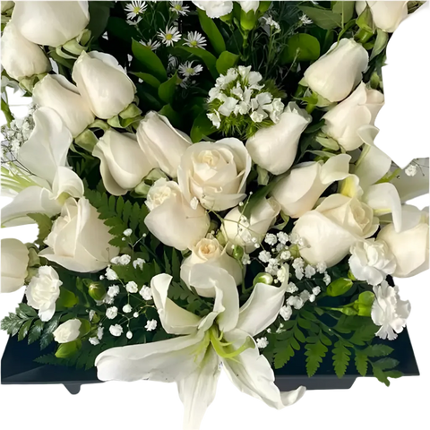 Detalle inferior de rosas blancas, lirio y follaje verde