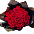 Imagen frontal de nuestro producto Buchón Elegante con Rosas es perfecto para expresar tu amor y romance. Con sus elegantes rosas rojas en un buchón negro, es un regalo ideal que demuestra tu amor de manera romántica y sofisticada. Floristería Flores 24 Horas en Bogotá, Domicilio.