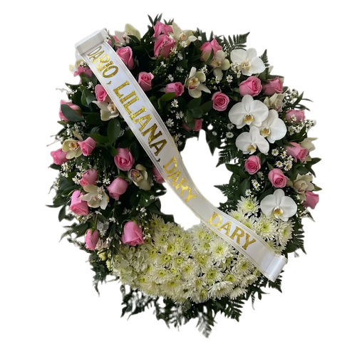 Detalle de rosas rosadas y orquídeas claras junto a una cinta funeraria blanca con letras doradas