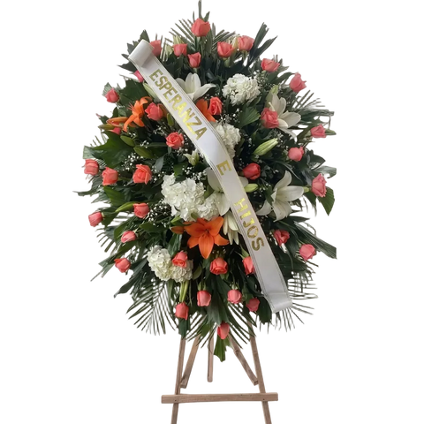 Corona Fúnebre Tranquilidad con lirios, rosas rosadas, hortensias y rosas blancas.