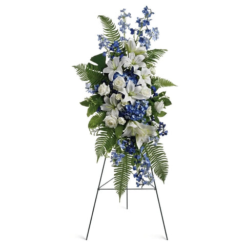 Pedestal y Arreglo Fúnebre, Corona y Pedestal "Brisa Del Océano". contiene: un caballete hortensias azules y delfinios, rosas blancas y lirios asiáticos, además de helechos y hojas tropicales. Flores 24 Horas, Bogotá, Colombia